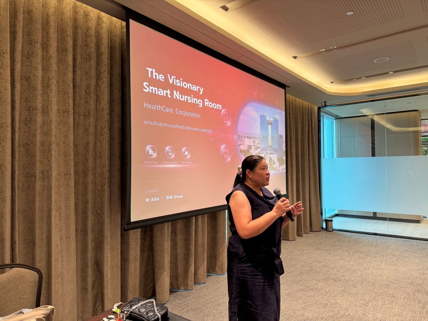 A W-Asia presenter giving a Smart Nursing Room health talk to staff in a meeting room