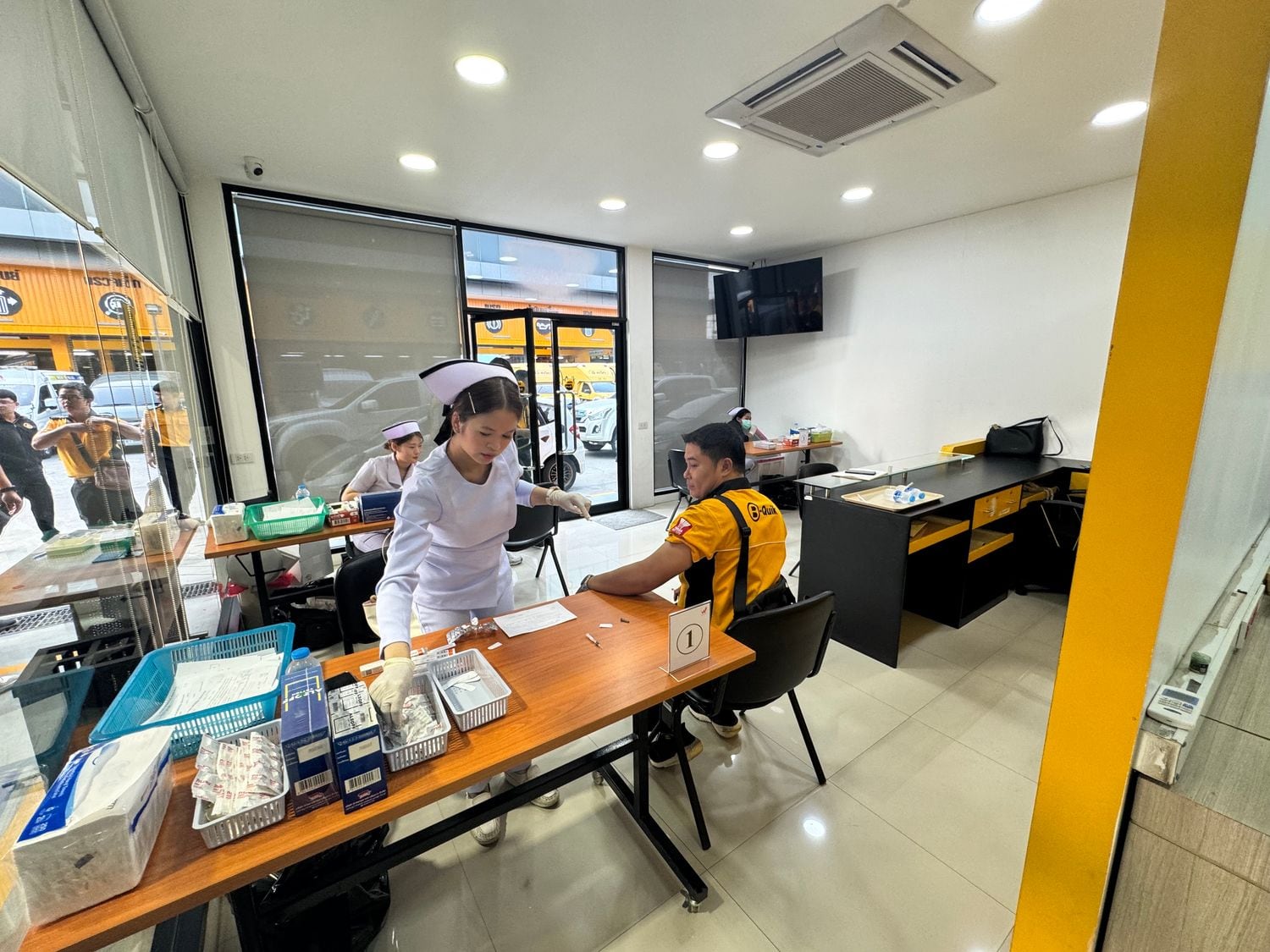 A W-Asia nurse registering a worker at the vaccination intake desk